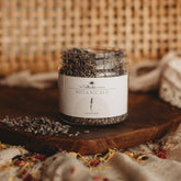 Jar of lavender on a wooden surface with a woven background.