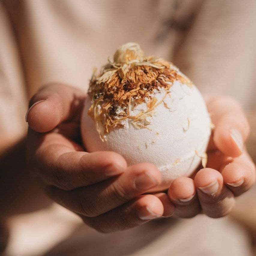 Person holding a play fizz ball with decorative elements in their hands