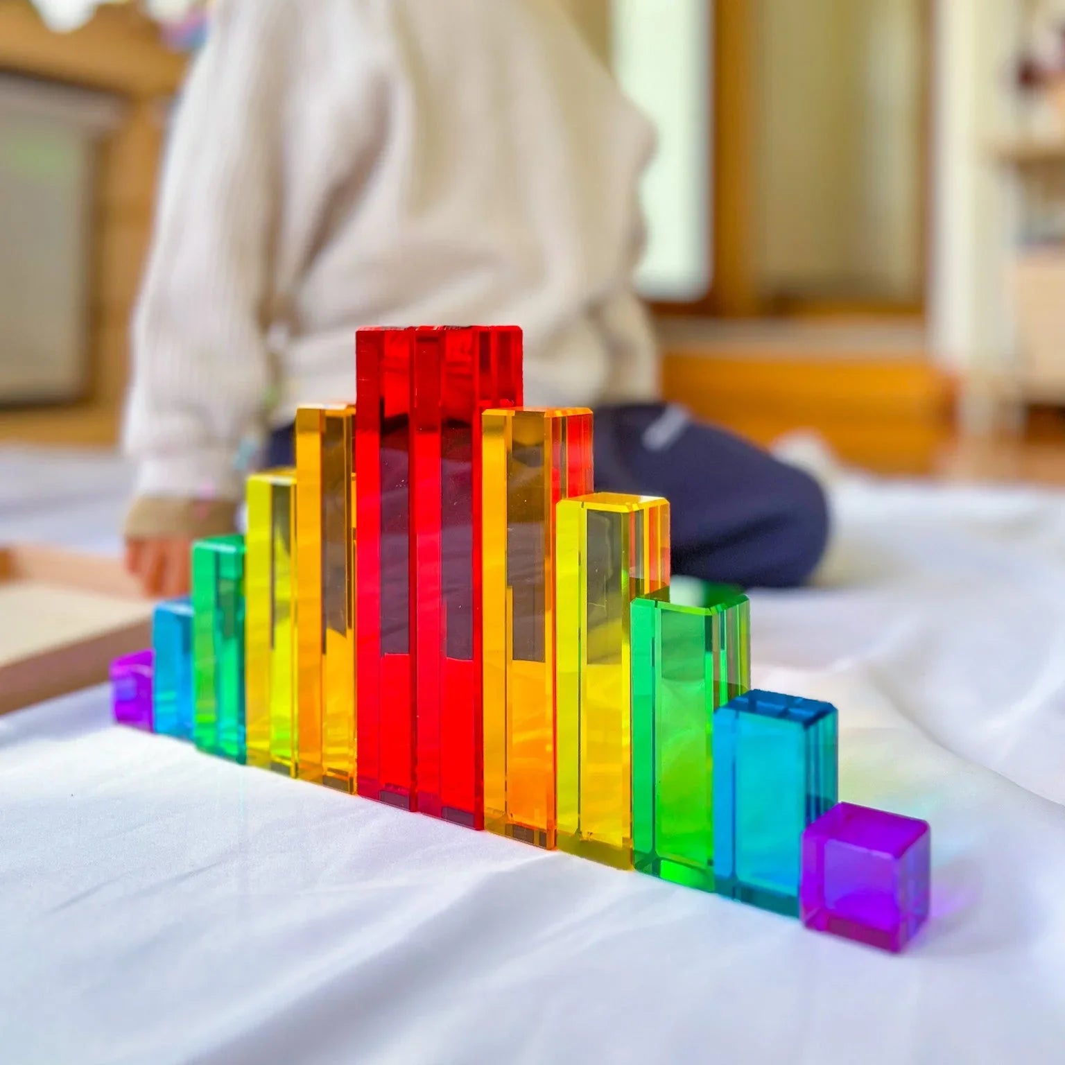 Child playing with colourful building blocks on the floor