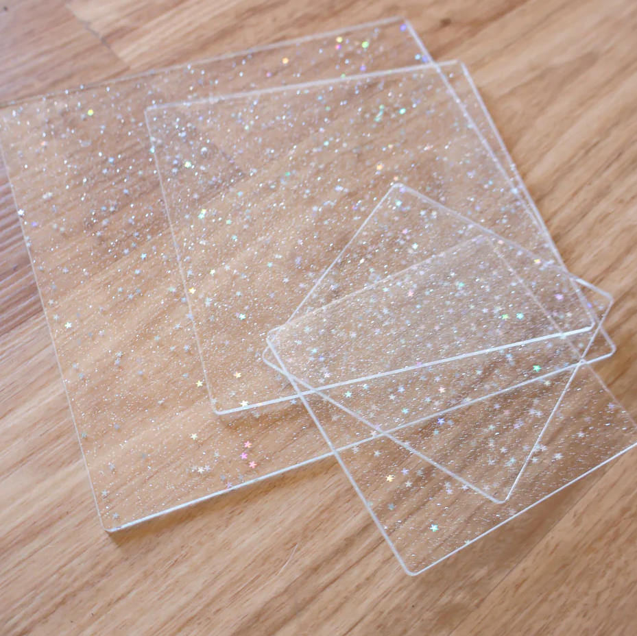 Clear acrylic platform with glittery specks on a wooden surface