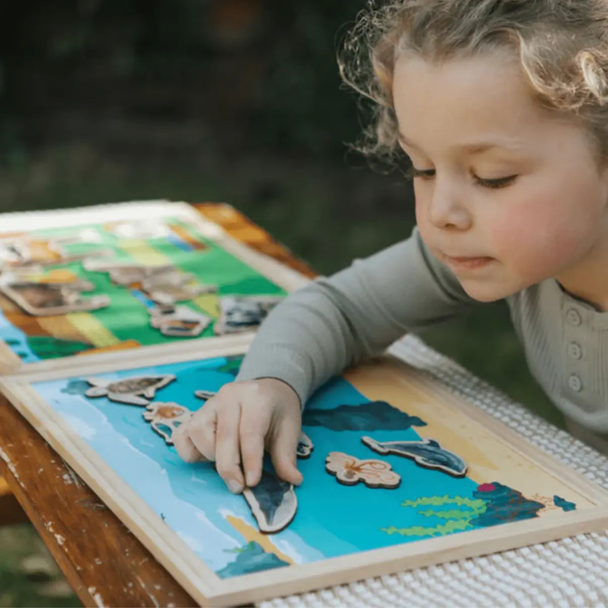 Child playing with a puzzle outdoors